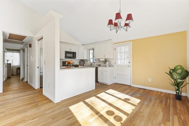 kitchen featuring light wood-style floors, white cabinets, black microwave, and light countertops