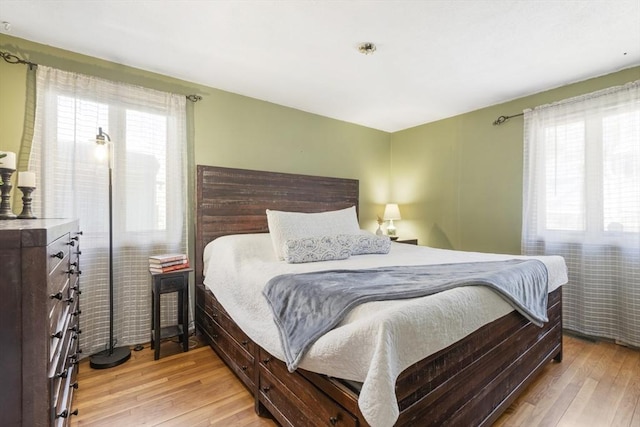 bedroom featuring multiple windows and light wood finished floors