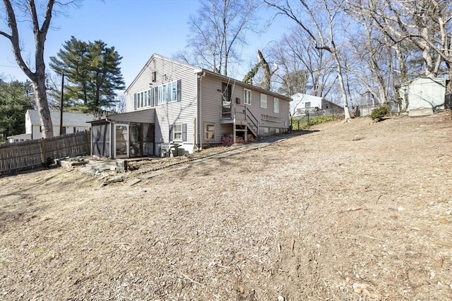 back of house featuring fence and a sunroom