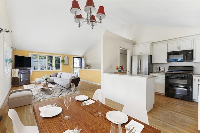 dining room featuring vaulted ceiling, baseboards, light wood-type flooring, and a chandelier