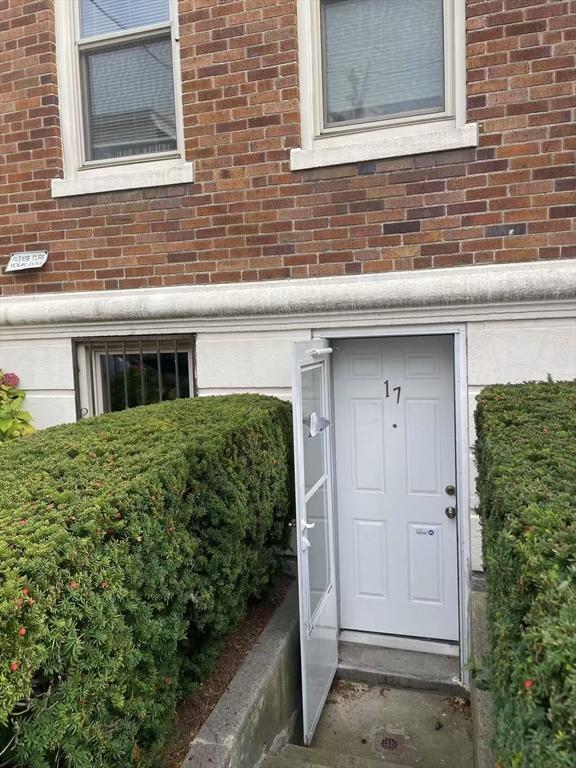 doorway to property featuring brick siding