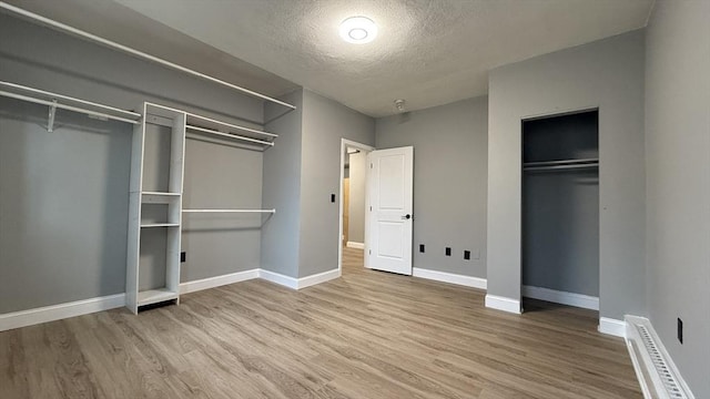 unfurnished bedroom featuring a closet, visible vents, baseboards, and wood finished floors