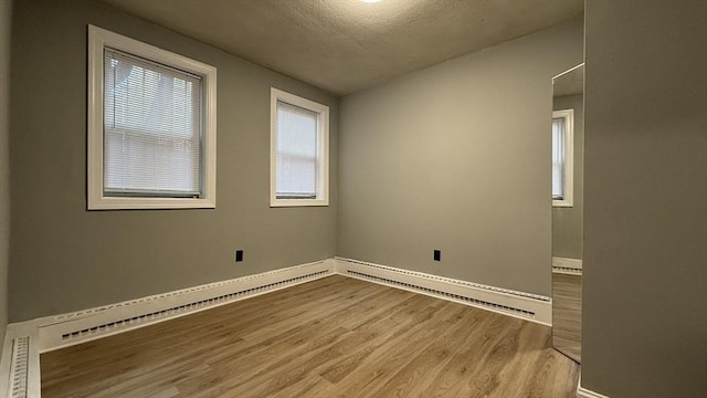 unfurnished room featuring baseboards, a textured ceiling, and wood finished floors