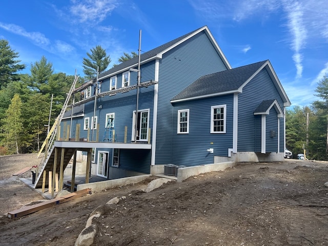 rear view of house featuring central AC