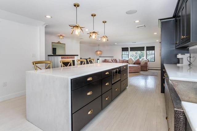 2 Overlook Rd, Canton, MA 02021 - kitchen featuring a kitchen island, dark cabinetry, stainless steel microwave, open floor plan, and hanging light fixtures
