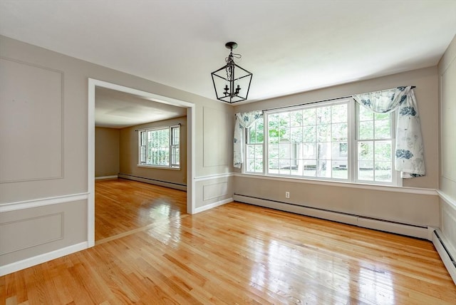 759 Williams St, Longmeadow, MA 01106 - spare room with baseboard heating, light wood-style floors, a chandelier, and a decorative wall