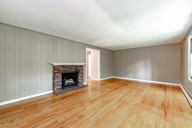 759 Williams St, Longmeadow, MA 01106 - unfurnished living room with wood finished floors, a brick fireplace, and a baseboard radiator