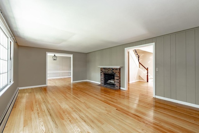 759 Williams St, Longmeadow, MA 01106 - unfurnished living room with a baseboard heating unit, light wood-type flooring, stairs, and a fireplace