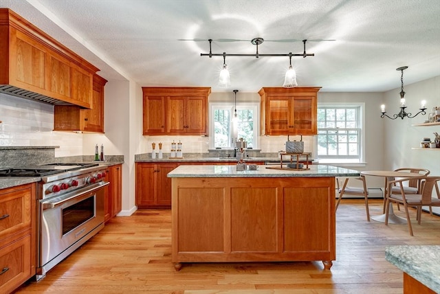 759 Williams St, Longmeadow, MA 01106 - kitchen featuring luxury stove, track lighting, backsplash, and brown cabinetry