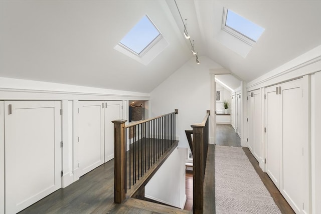 hall featuring lofted ceiling with skylight, dark wood finished floors, and an upstairs landing