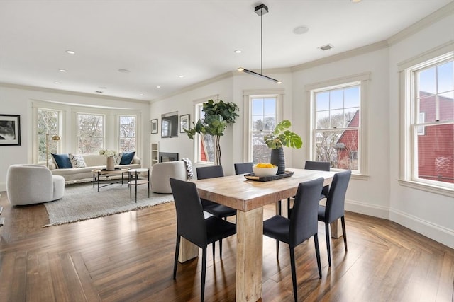 dining room featuring plenty of natural light, baseboards, and crown molding