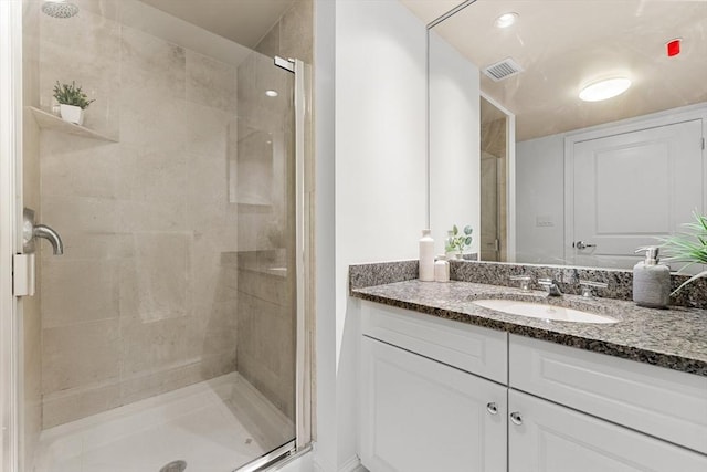 bathroom featuring a shower stall, visible vents, and vanity