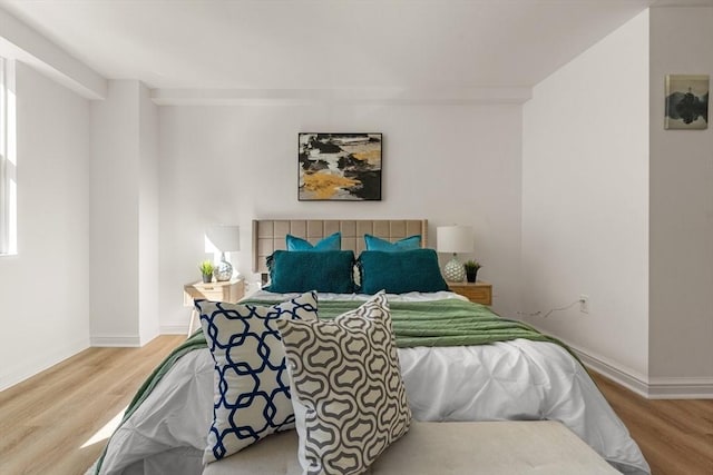 bedroom with baseboards and wood finished floors