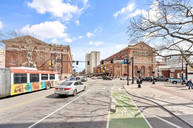 view of street with traffic lights, curbs, sidewalks, and street lights