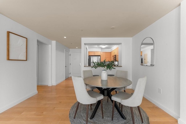 dining space with light wood finished floors, baseboards, and recessed lighting