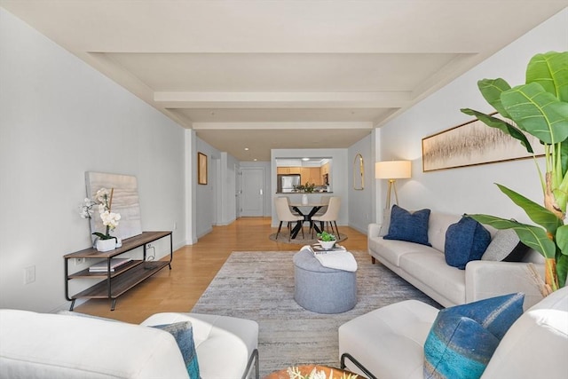 living area with light wood finished floors and beamed ceiling