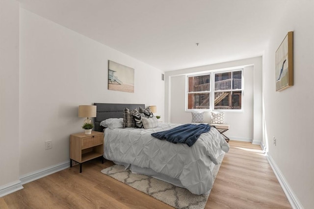 bedroom featuring baseboards and light wood-style floors