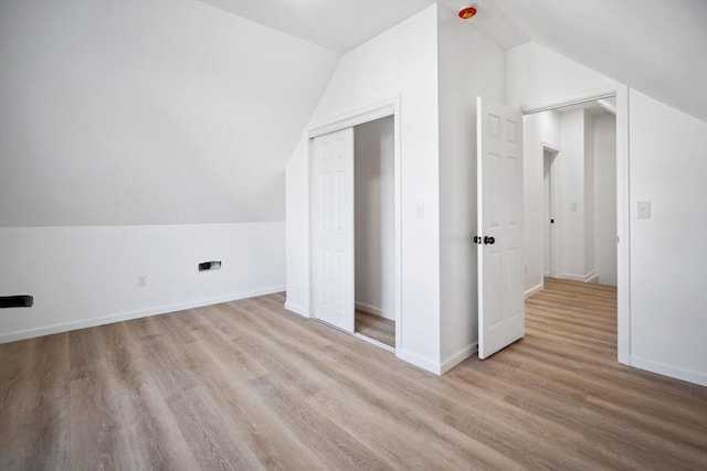 additional living space with lofted ceiling and light wood-type flooring