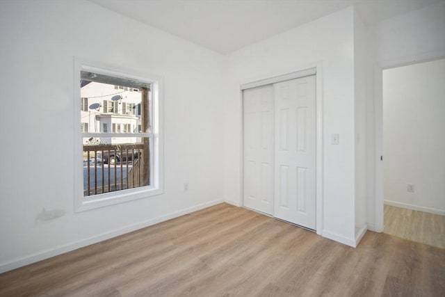 unfurnished bedroom with light hardwood / wood-style flooring and a closet