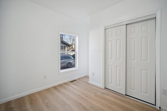 unfurnished bedroom featuring light hardwood / wood-style floors and a closet