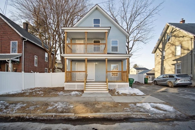 view of front property with a balcony and covered porch