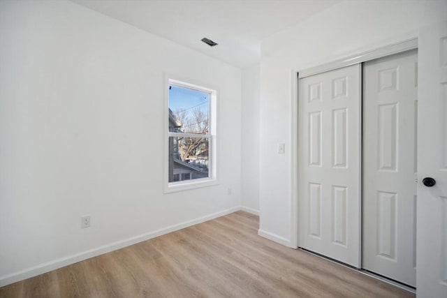 unfurnished bedroom featuring a closet and light hardwood / wood-style flooring