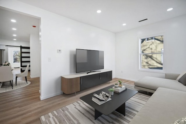 living room with light hardwood / wood-style floors and a barn door