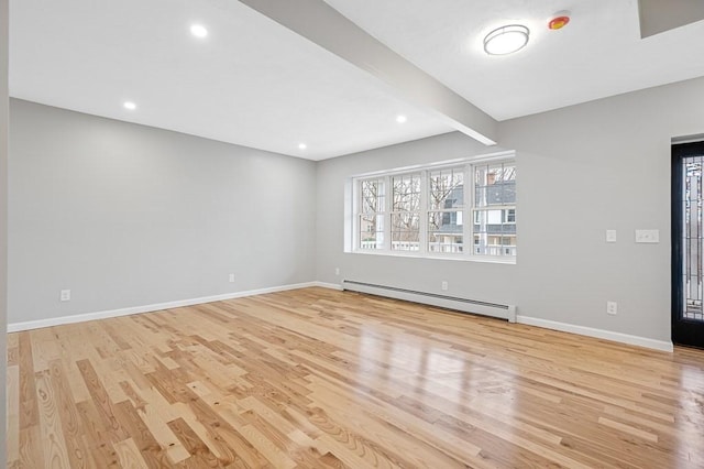 unfurnished living room featuring light wood-type flooring, a baseboard radiator, and baseboards