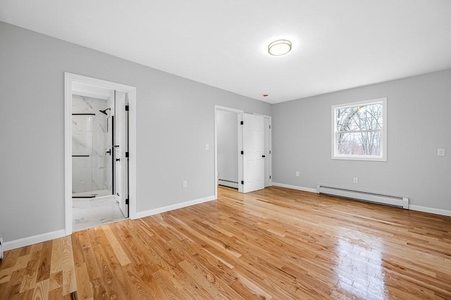 unfurnished bedroom with light wood finished floors, baseboard heating, and baseboards