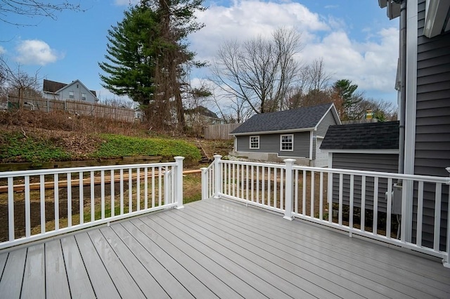 wooden terrace featuring fence and an outdoor structure