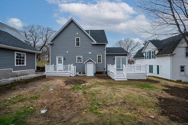 rear view of property with a deck and a lawn
