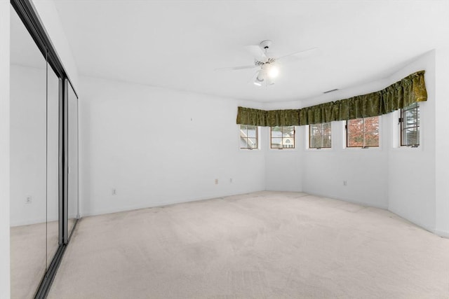 unfurnished room with light carpet and ceiling fan