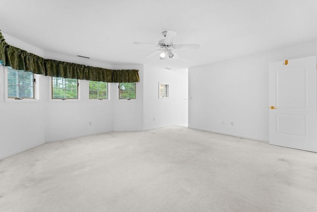 carpeted empty room featuring a healthy amount of sunlight and ceiling fan