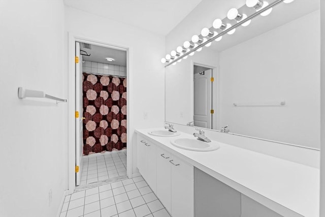 bathroom with double vanity, curtained shower, tile patterned flooring, and a sink