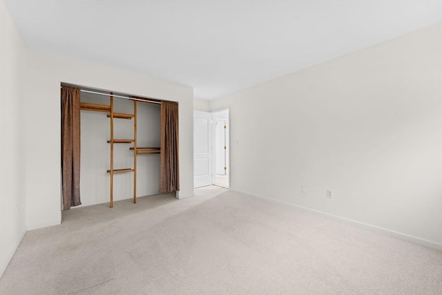 unfurnished bedroom featuring carpet floors, baseboards, and a closet