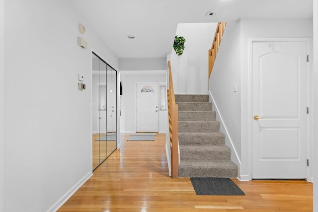 staircase with baseboards, wood finished floors, and recessed lighting