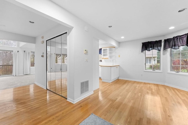 unfurnished room with light wood-style floors, recessed lighting, visible vents, and baseboards