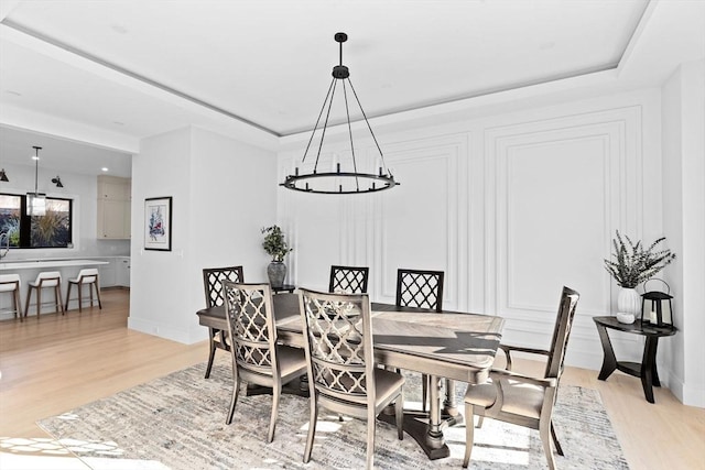 dining space featuring a notable chandelier and light wood-type flooring