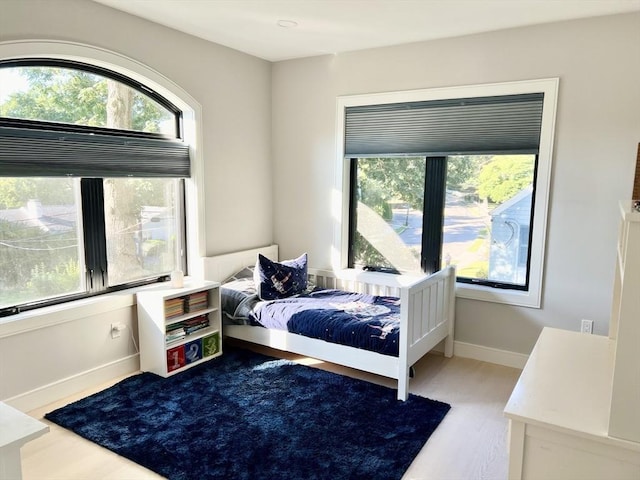 bedroom featuring multiple windows and light wood-type flooring