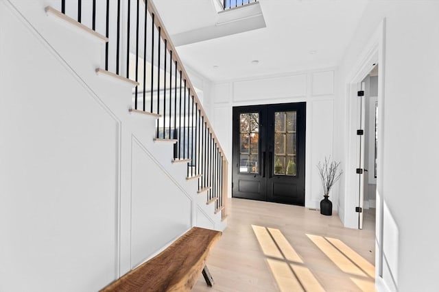 foyer featuring light hardwood / wood-style flooring and french doors