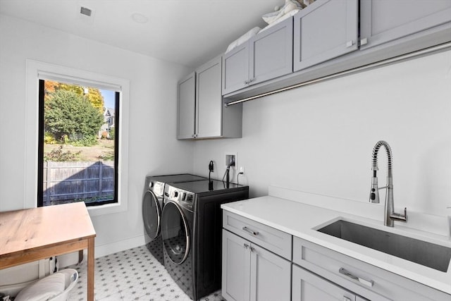 laundry area with separate washer and dryer, sink, and cabinets