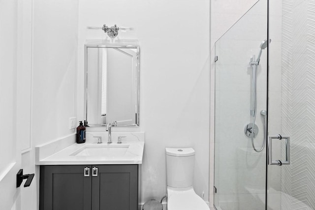 bathroom with vanity, a shower with shower door, and toilet