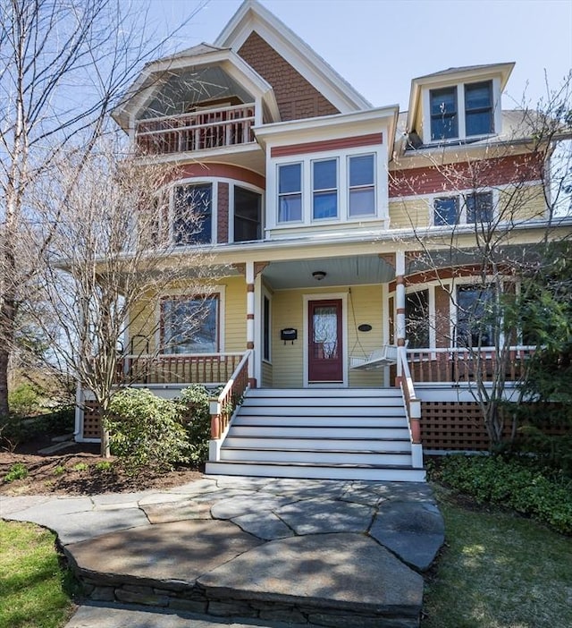 view of front of property featuring covered porch and a balcony