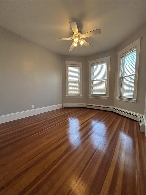 empty room with ceiling fan, baseboards, baseboard heating, and dark wood-style flooring