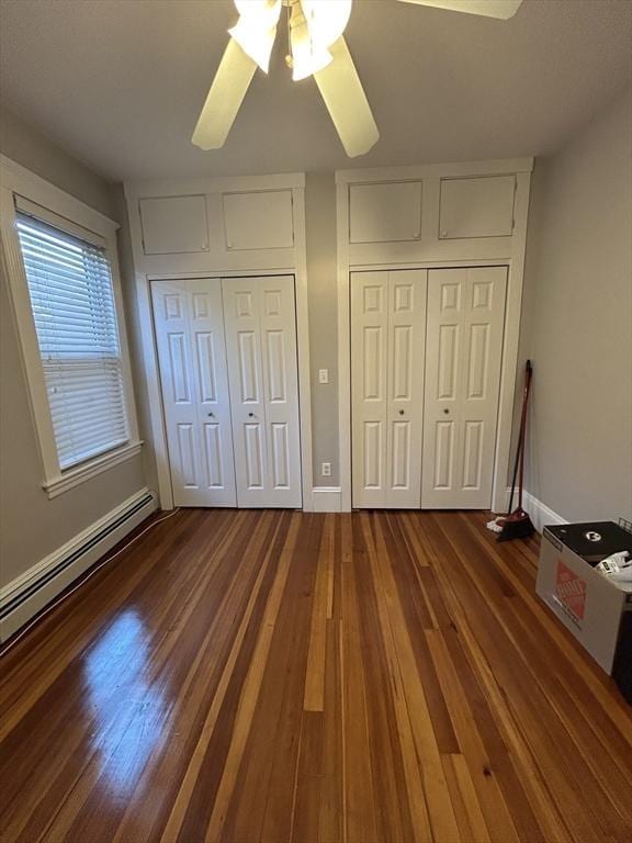 unfurnished bedroom with baseboards, a baseboard radiator, a ceiling fan, and wood finished floors