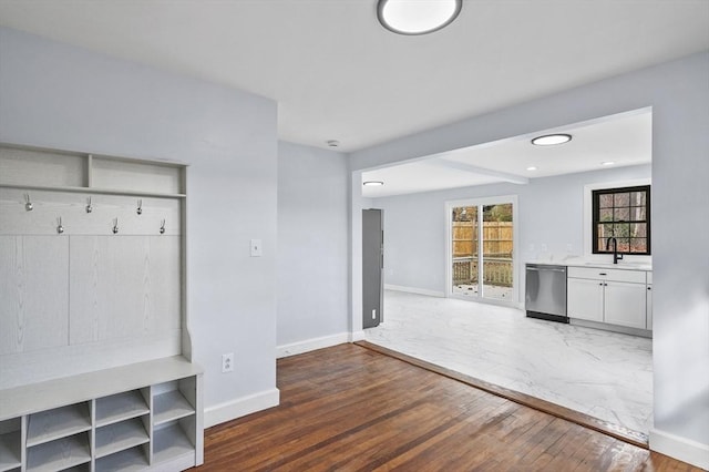 mudroom with wood-type flooring, a sink, and baseboards