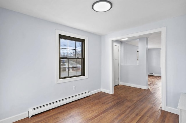 empty room with baseboard heating, a baseboard radiator, dark wood finished floors, and baseboards