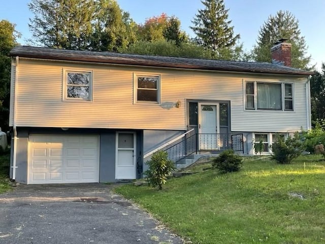 split foyer home featuring a front yard, a chimney, and an attached garage