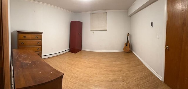 interior space with light wood-style floors, a baseboard radiator, baseboards, and crown molding