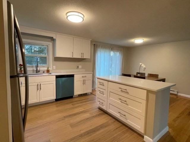 kitchen with light wood-style flooring, white cabinetry, dishwasher, and freestanding refrigerator